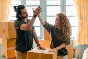 two people settling into a new rental and high-fiving each other