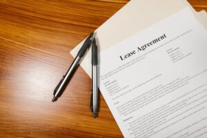 A lease agreement on a wooden surface with two silver pens